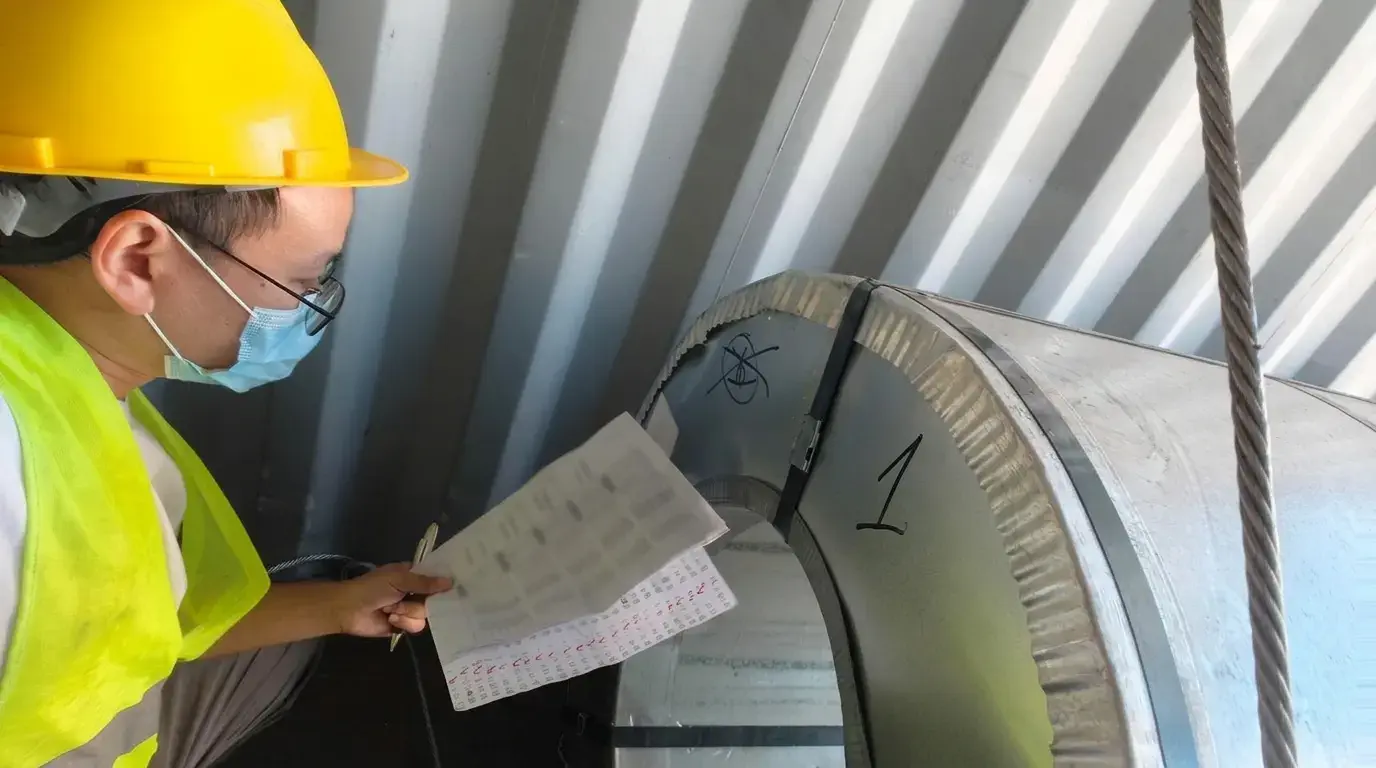 Inspector checking steel coil identification and batch records